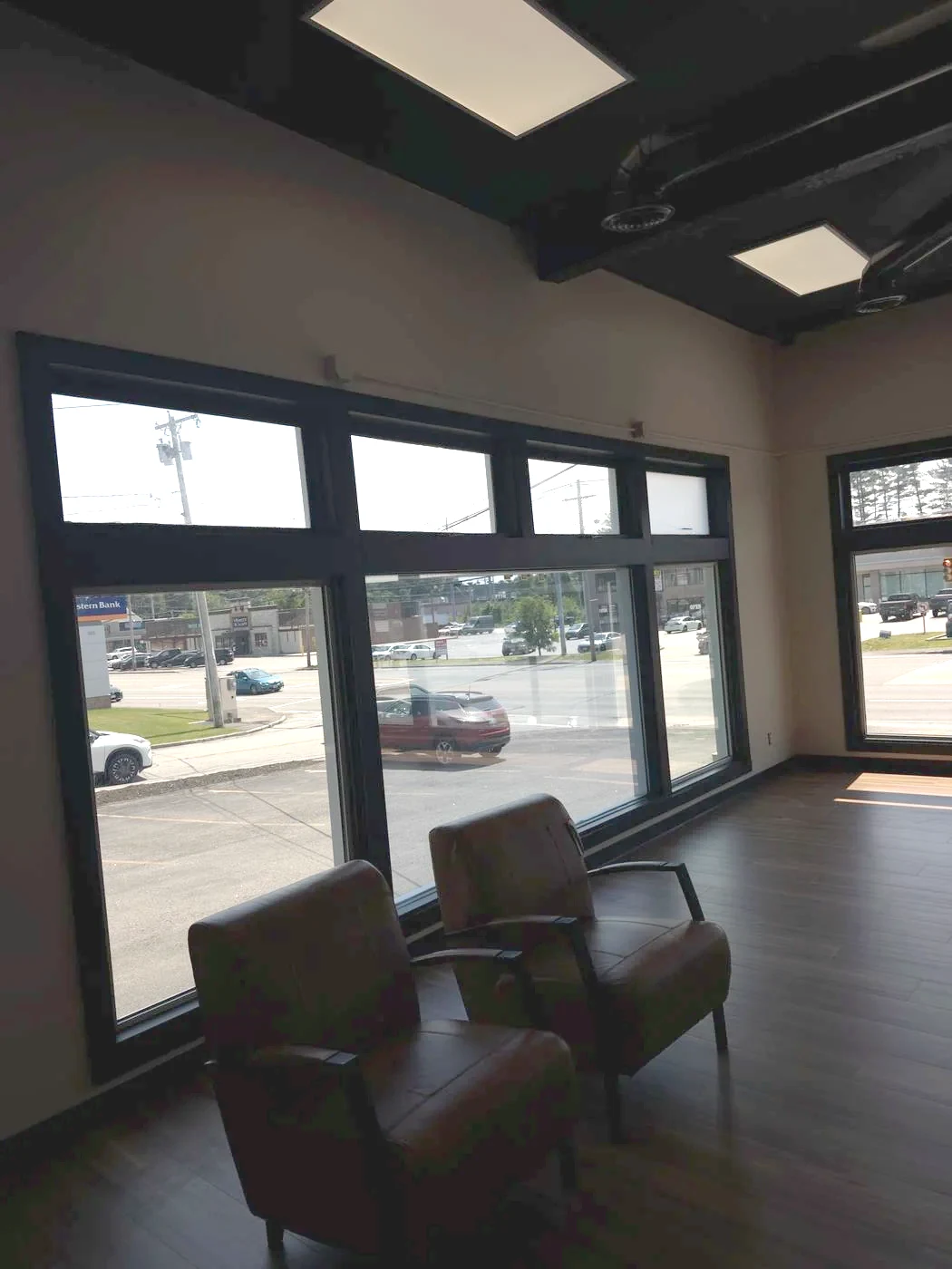 A completed commercial room with clean flooring and bright street-facing windows, ready for use